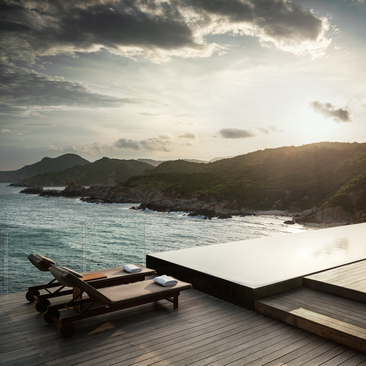One-bedroom ocean pool residence with infinity pool overlooking turquoise waters, distant mountains and coastline at Amanoi, Vietnam.