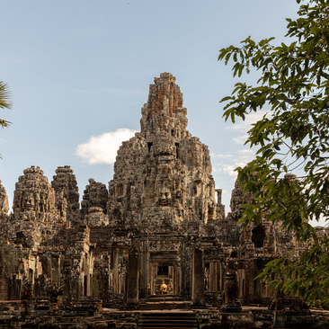 Bayon Temple's stone towers rise through verdant foliage at Amansara's Angkor temple tour.