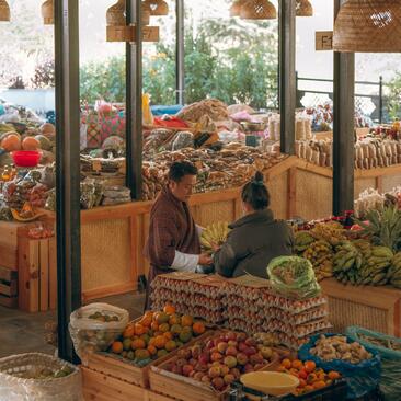 Vendor arranging fresh produce at Thimphu farmers' market, Amankora, Bhutan.