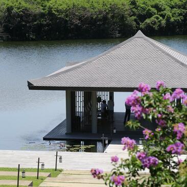 Pavilion at Amanoi with magenta bougainvillea flowers overlooking still waters.