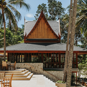 Famp B Arva Italian restaurant exterior at Amanpuri resort in Thailand, with traditional wooden pitched roof and dining terrace.