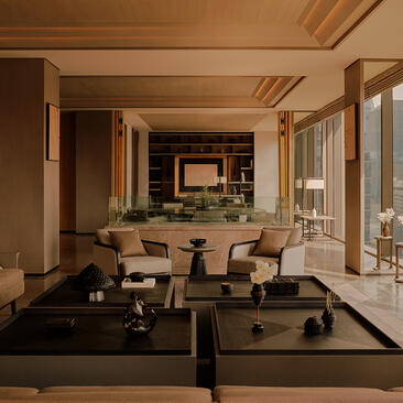 Aman Nai Lert Bangkok suite with circular seating arrangement, wooden beams, and floor-to-ceiling windows overlooking the city.