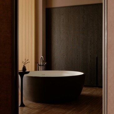 Freestanding black bathtub in a spa bathroom at Aman Nai Lert Bangkok, with warm wood panelling and soft lighting.