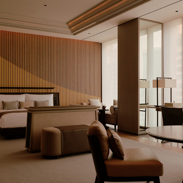 Principal bedroom at Aman Nai Lert Bangkok with warm wood panelling and contemporary furnishings.