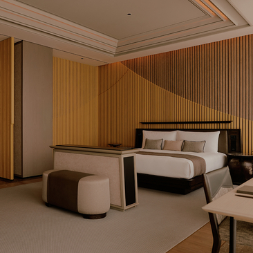 Principal bedroom at Aman Nai Lert Bangkok with warm wood panelling, platform bed, and contemporary furnishings.