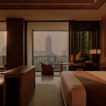 Terrace suite at Aman Nai Lert Bangkok with floor-to-ceiling windows overlooking the city skyline.