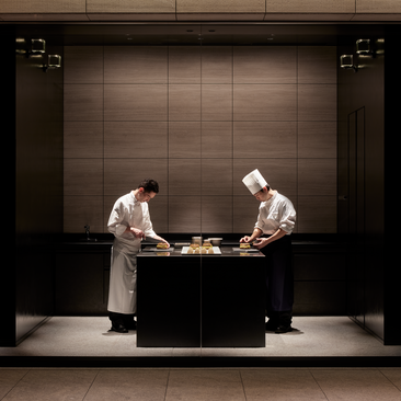 Two chefs prepare food at a counter in La Pâtisserie at Aman Tokyo.