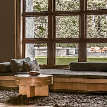 Thimphu lodge suite with wooden banquette seating and large windows overlooking gardens at Amankora.