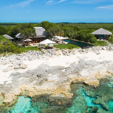 Villa 33 beachfront exterior at Amanyara, with white sand shore and turquoise waters.