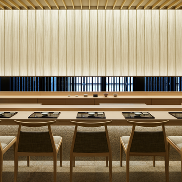Three olive chairs face a minimalist corridor with vertical wood cladding and blue accents at Aman Tokyo.