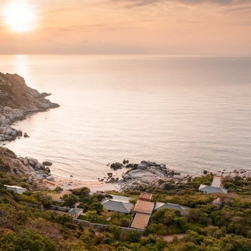 Aerial view of Amanoi ocean pool residence overlooking the Vietnamese coast at sunset.