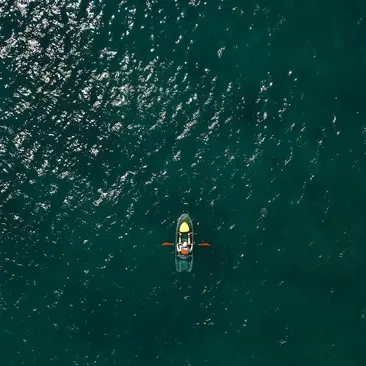 Aerial view of a traditional wooden boat on emerald waters at Amanoi, Vietnam.
