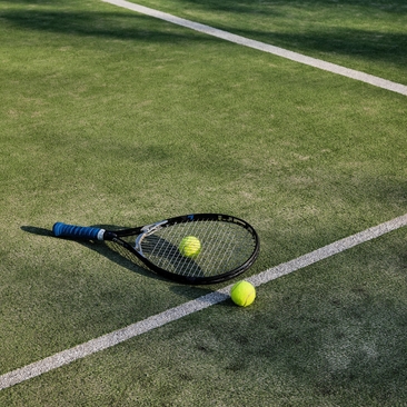 Tennis racket and balls on court at Amanpulo resort.