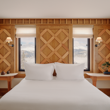 Chambre Nord bedroom at Aman Le Mélézin with geometric wood panelling and mountain views.