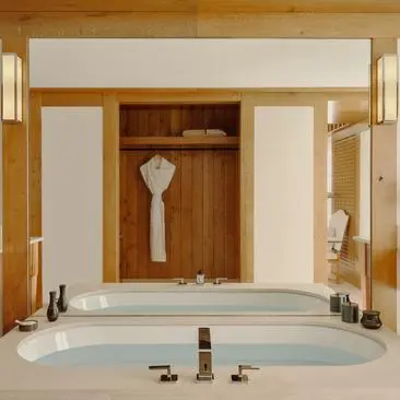 Chambre avec baignoire encastrée et boiseries en mélèze, Aman Le Mélézin.