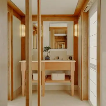 Salle de bains épurée avec lavabo en bois et miroir, Aman Le Mélézin.