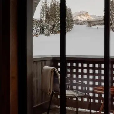 Fenêtre d'appartement familial à Aman Le Mélézin offrant une vue sur les montagnes enneigées.