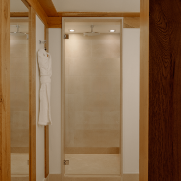 Spacious walk-in shower with glass enclosure at Aman Le Mélézin family apartment.