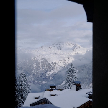 Snowy alpine peaks viewed through a window at Aman Le Mélézin, France.