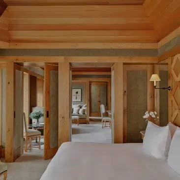 Suite Mélézin avec boiseries en bois clair et lit double à Aman Le Mélézin.