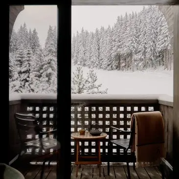Suite avec vue sur les pistes enneigées, Aman Le Mélézin, station de montagne française.