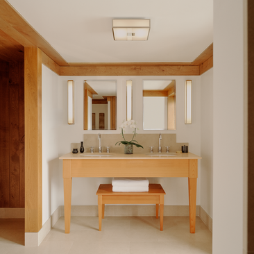 Wooden vanity with dual basins and mirror in suite bathroom at Aman Le Mélézin.