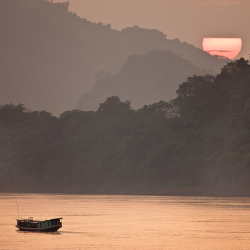 Wooden boat on the Mekong River at sunset, Luang Prabang, as seen from Amantaka.