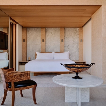 安缦卓熠度假村的三卧室别墅卧室，设有白色床铺、木质特色墙面和现代家具。