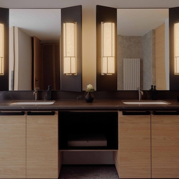 Principal bedroom ensuite at Aman Rosa Alpina with dual vanities and illuminated mirror panels.