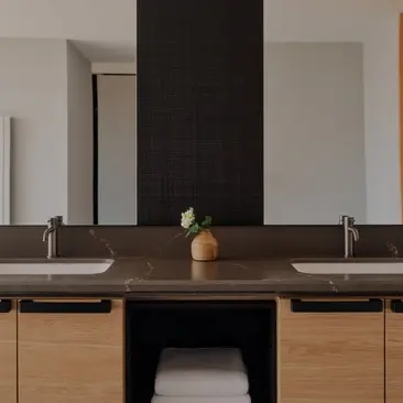 Salle de bains de la Suite Premier à Aman Rosa Alpina, avec double vasque et miroir noir.