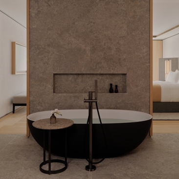 Rosa Alpina Suite bathroom with freestanding black bathtub and terracotta feature wall at Aman Rosa Alpina.