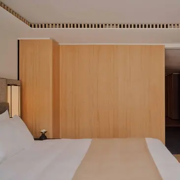 Superior Room at Aman Rosa Alpina resort, featuring warm wood panelling and contemporary furnishings.