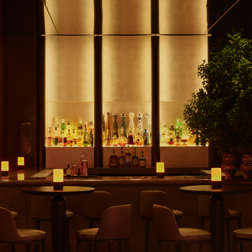 アマン ニューヨークのジャズクラブ。暖かい照明に包まれたバーカウンター、キャンドルが灯る落ち着いた夜の雰囲気。