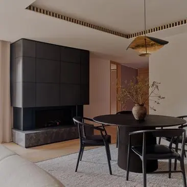 Aman Suite at Aman Rosa Alpina resort featuring a fireplace and dining area with modern furnishings.