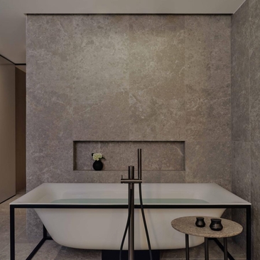 Aman Rosa Alpina bathroom with concrete walls, rectangular bathtub and minimalist fixtures.