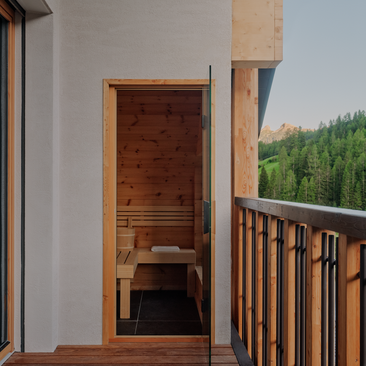Dolomites Suite sauna with wooden door and mountain views from balcony at Aman Rosa Alpina.