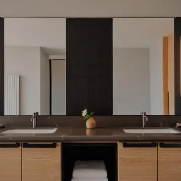 Bathroom at Aman Rosa Alpina resort with dual vanities, large mirrors, and minimalist design.