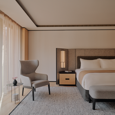 Rosa Alpina Suite Room 107: principal bedroom with bed, armchair and floor-to-ceiling windows overlooking Italian Alps.