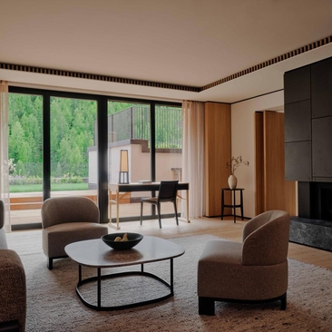 Rosa Alpina Suite with seating area, fireplace and views across the Dolomites, Room 107 at Aman Rosa Alpina, Italy.