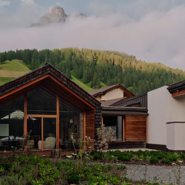 Zeno Suite at Aman Rosa Alpina with views of forested Dolomite slopes and mountain peaks beyond.
