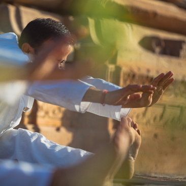 Homme tenant une plante verte à Amanjiwo, la station balnéaire, à la lumière douce du jour.