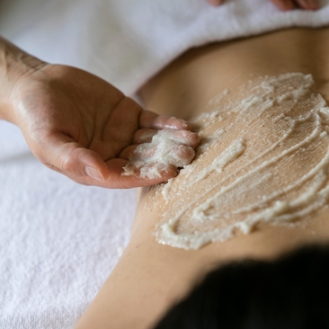 Spa therapist applying exfoliating scrub to guest's arm at Amanjiwo.