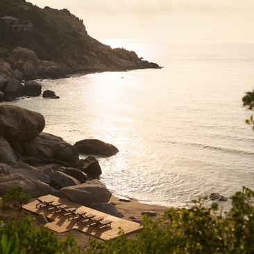 Amanoi Ocean Pool Residence overlooks a rocky Vietnamese coastline and private beach at dawn.