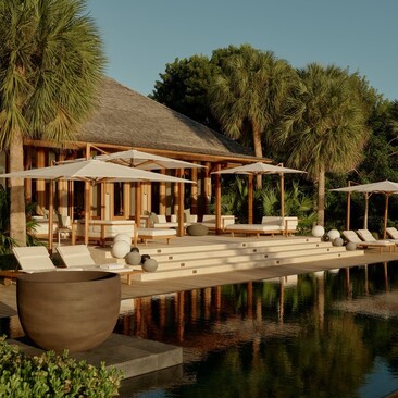 Outside living area of a villa at Amanyara, with seating pavilion overlooking a reflecting pool.