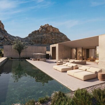 Amangiri residence with infinity pool overlooking desert mountains and sandy landscape at dusk.