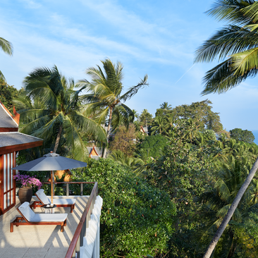 安缦璞瑞度假村四卧海景别墅的露台，配有日光浴床，俯瞰热带花园和蓝天。