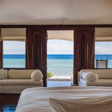 Ocean view from a bedroom tent at Amanwana, Indonesia, with the sea visible through open doors.