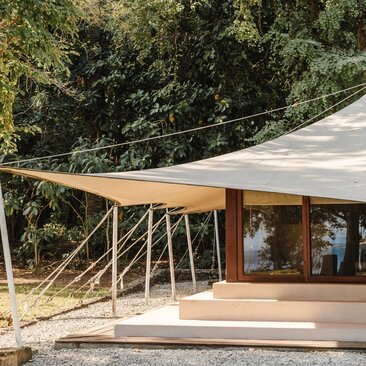 Canvas tent with wooden deck overlooking ocean at Amanwana, Indonesia.