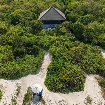 Casita avec piscine privée entourée de végétation tropicale à Amanpulo, resort.