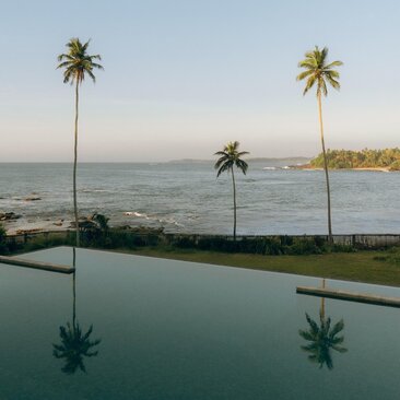 Amanwella pool with views over the Indian Ocean and palm trees, Sri Lanka.